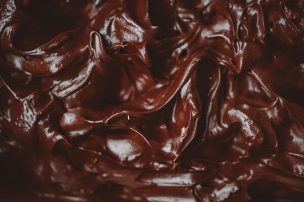 Close-up of a decadent and velvety chocolate ganache, showing its rich texture.