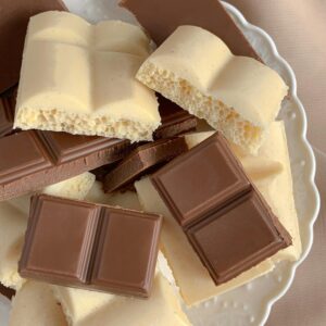 Close-up of a mix of milk and white chocolate bars on a decorative plate.
