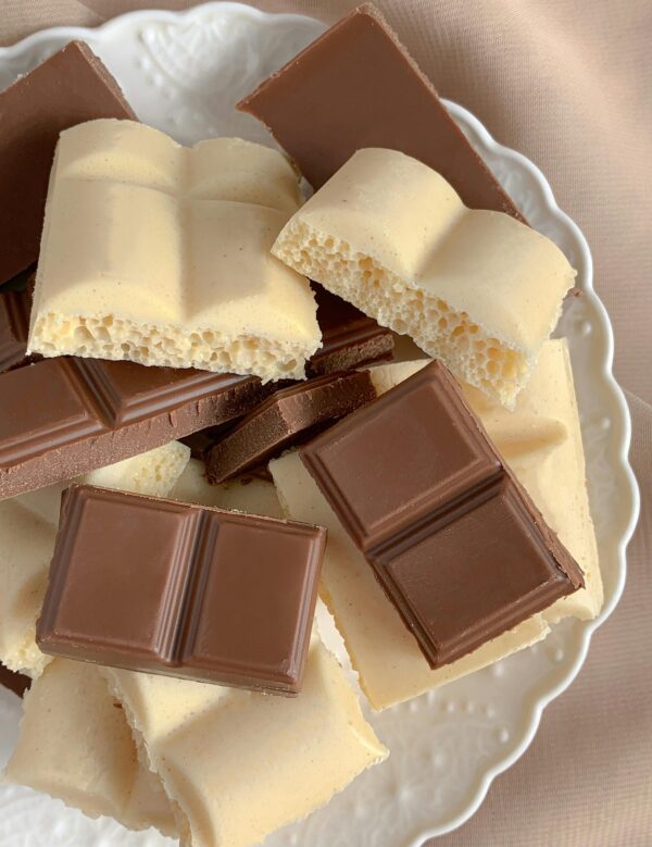 Close-up of a mix of milk and white chocolate bars on a decorative plate.