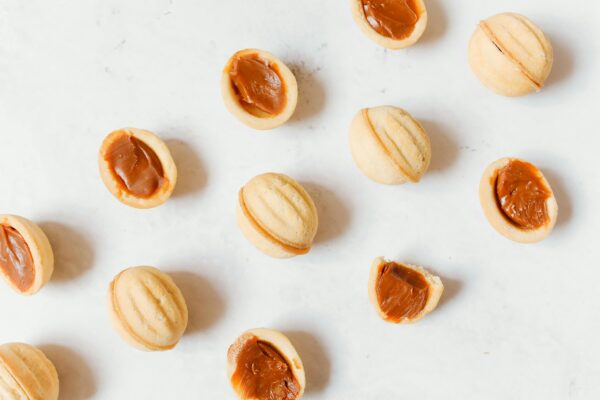 Top view of traditional Russian oreshki cookies with caramel filling on a white background.